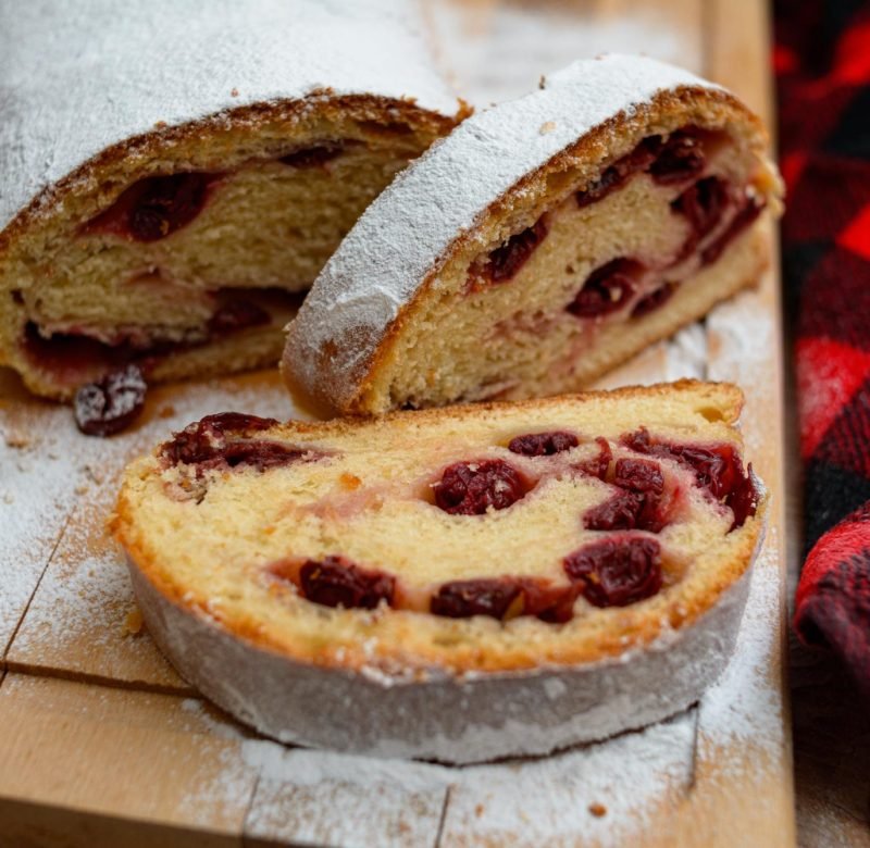 roll-cake-with-cherry-filling-covered-with-sugar-powder-cutting-board